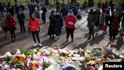 People mourn at a memorial site at the Clapham Common Bandstand, following the kidnap and murder of Sarah Everard, in London, Britain, March 14, 2021. 