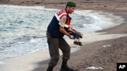 Polisi paramiliter menggendong mayat anak migran yang tidak diidentifikasi, di pantai dekat Bodrum, Turki (2/9). 