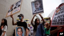 Supporters of Edward Snowden, a former CIA employee who leaked top-secret information about U.S. surveillance programs, hold placards as they march to the Consulate General of the United States in Hong Kong, June 15, 2013.