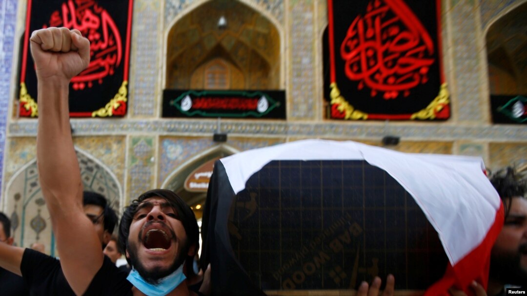 FILE - Mourners carry the coffin of Reham Yacoub, a female activist who was killed by unidentified gunmen, during her funeral in the holy city of Najaf, Iraq, Aug. 20, 2020. 