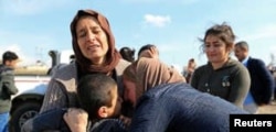 FILE - Relatives hug a Yazidi survivor boy following his release from IS militants in Syria, in Duhok, Iraq, March 2, 2019.