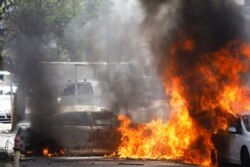 Cars go up in flames after a rocket launched from the Gaza Strip landed nearby, in Ashkelon, southern Israel, May 11, 2021.