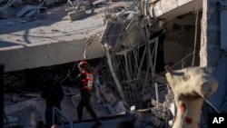 An officer from the home front command military unit examines damage after shrapnel from a Houthi missile collapsed a school building in Ramat Gan, a suburb of Tel Aviv, Israel, Dec. 19, 2024. 