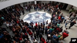 FILE - Dozens of Mexican federal police gather at a police command center in the Iztapalapa borough, in Mexico City, to protest against plans to force them into the newly formed National Guard, July 3, 2019.