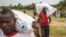 FILE - People carry food aid from a British Navy helicopter after it made a food drop on Sherbro Island, Sierra Leone, Dec. 7, 2014. 