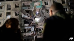 Rescue workers clear the rubble inside a building damaged by a Russian airstrike in Kharkiv, Ukraine, Oct. 3, 2024. 