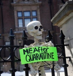 FILE - A mock skeleton is attached to a fence outside Minnesota Gov. Tim Walz's official residence in St. Paul, Minn., the site of a protest against stay-at-home restrictions, April 17, 2020.