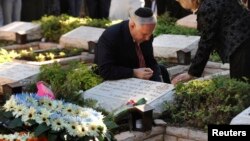 Le premier ministre israélien Benjamin Netanyahu allume une bougie pour commémorer la mort de son frère Yonathan sur sa tombe, mort en 1976 lors du raid israélien sur Entebbe, le 28 juin 2009.