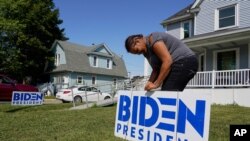 3일 미국 위스콘신주 커노샤에서 조 바이든 민주당 대선 후보 방문을 앞두고 한 주민이 집 앞마당에 지지 표지판을 꼽고 있다.
