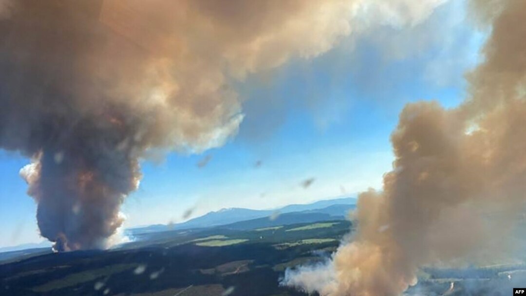 This file handout photo courtesy of BC Wildfire Service shows two plumes of smoke from the Long Loch wildfire and the Derrickson Lake wildfire, British Columbia, on June 30, 2021.