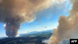 This file handout photo courtesy of BC Wildfire Service shows two plumes of smoke from the Long Loch wildfire and the Derrickson Lake wildfire, British Columbia, on June 30, 2021.