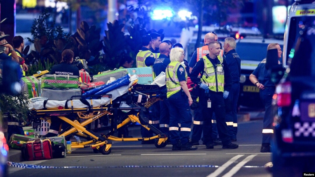 Miembros de los servicios de emergencia y policías aguardan a las afueras del centro comercial Westfield Bondi Junction en Sidney, Australia, tras un ataque de un hombre contra compradores y visitantes, este sábado 13 de abril de 2024.