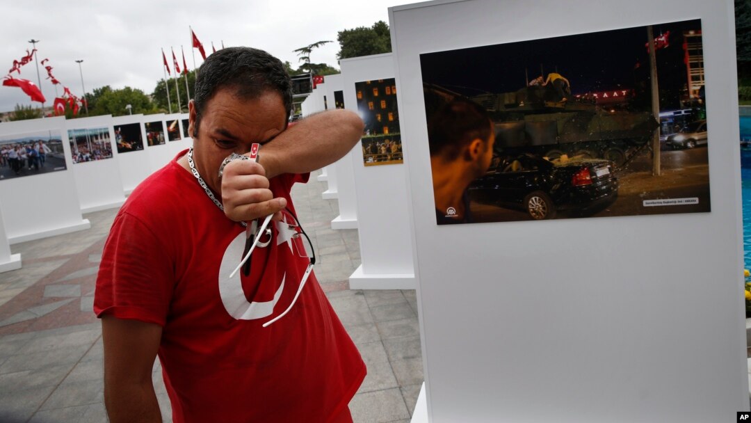 Savas Altay weeps as he visits an outdoor exhibition featuring photographs of July 15, 2016, coup attempt, in Istanbul, July 14, 2017. Turkey commemorates the anniversary with events honoring about 250 people who were killed while trying to oppose coup-plotters.