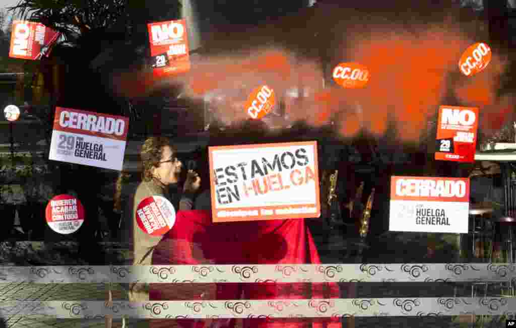 A window covered with red paint and strike stickers reading 'We are on Strike' and 'Closed for the General Strike' in Madrid, March 29, 2012. (AP)