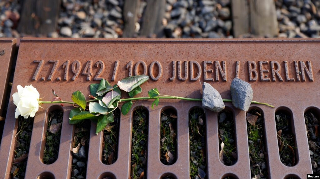 FILE - A rose lies at the Gleis 17 (Platform 17) memorial, a platform at Berlin-Grunewald train station from which Jewish citizens were deported by train to the Nazi concentration camps between 1941 and 1945, in Berlin, Germany, Jan. 27, 2021. 