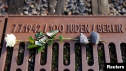 FILE - A rose lies at the Gleis 17 (Platform 17) memorial, a platform at Berlin-Grunewald train station from which Jewish citizens were deported by train to the Nazi concentration camps between 1941 and 1945, in Berlin, Germany, Jan. 27, 2021. 