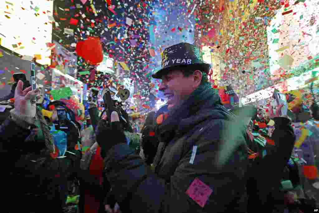 A reveler celebrates as confetti falls during a New Year's celebration in New York's Times Square, Jan. 1, 2019.