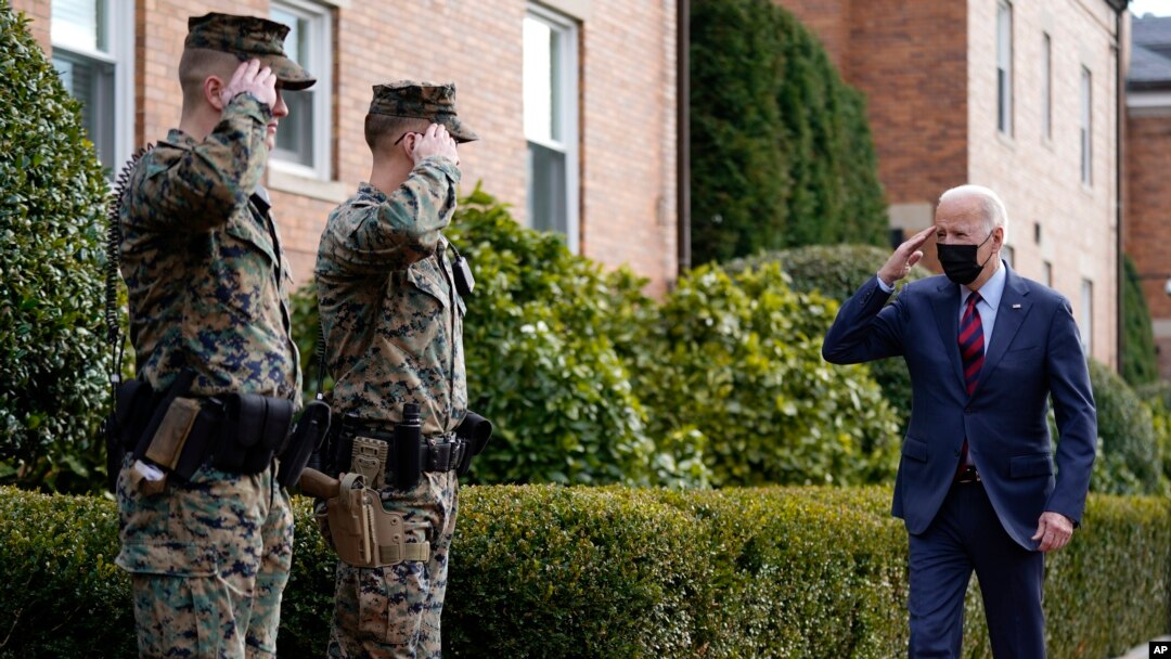 Presiden AS Joe Biden memberikan salam hormat ketika ia berjalan melewati barak Angkatan Laut Washington setelah mengunjungi sebuah toko di kota tersebut, pada 25 Januari 2022. (Foto: AP/Andrew Harnik)