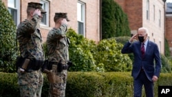 El presidente Joe Biden devuelve un saludo mientras camina por Marine Barracks Washington después de visitar la tienda Honey Made, el martes 25 de enero de 2022, en Washington.