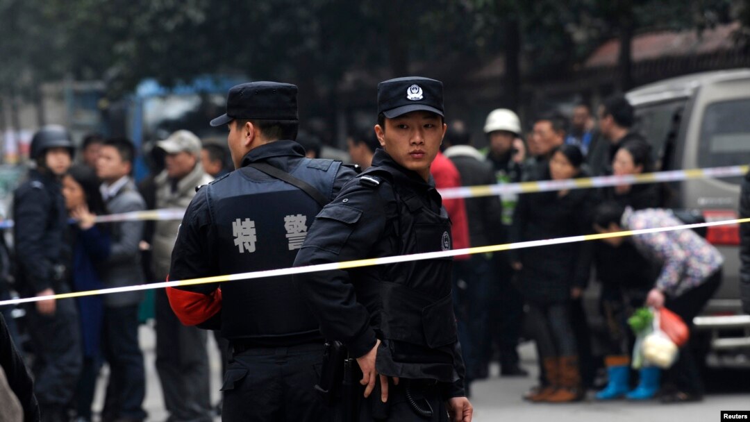 Police stand guard at a crime scene after a knifing incident in Changsha, Hunan province, March 14, 2014. At least three people are dead after the knifing incident in central China's Changsha city, state media reported on Friday, in what appeared to be a 