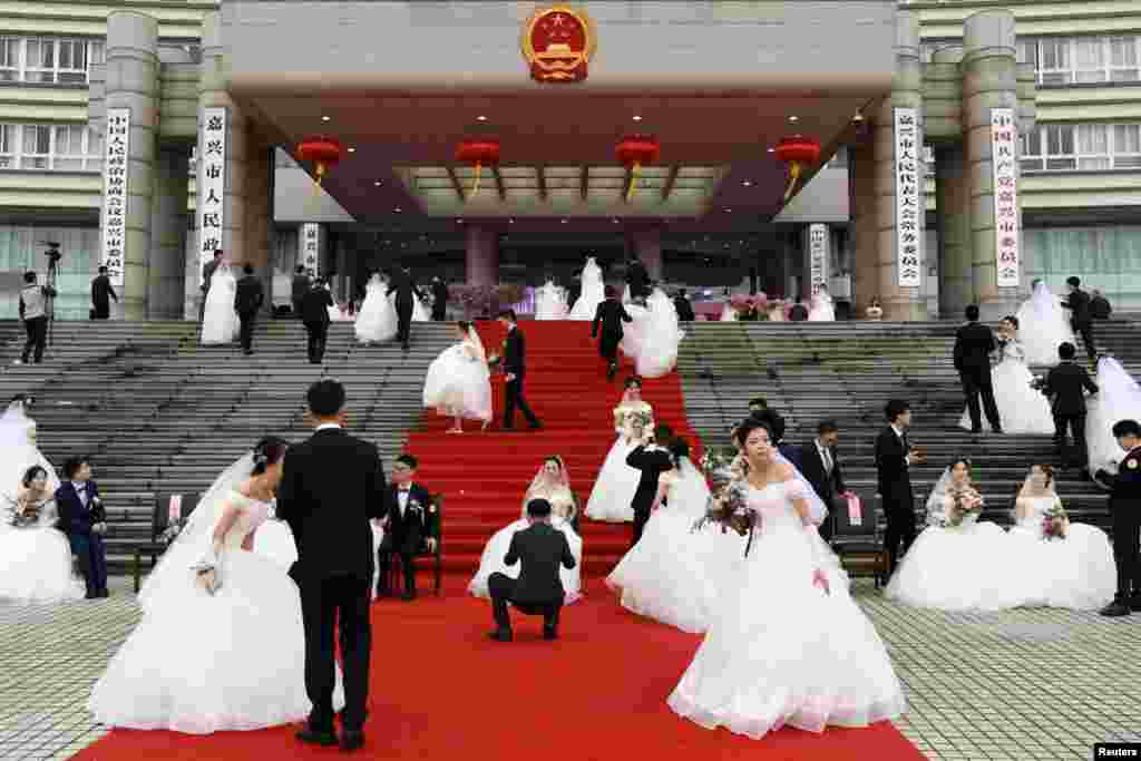 Couples attend a mass wedding at the city's municipal government building in Jiaxing, Zhejiang province, China.