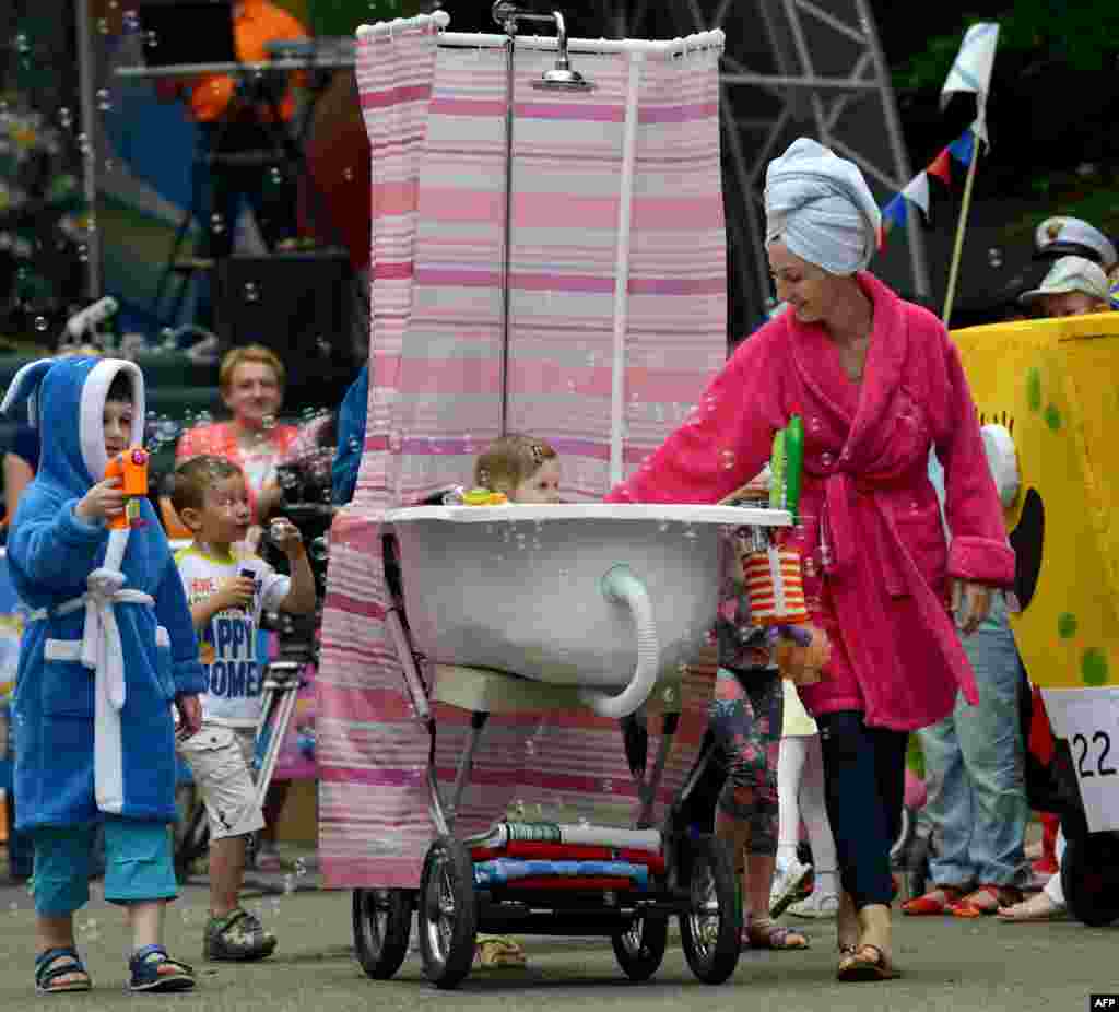 A father pushes a self-made stroller designed to figure a bathtub during a &quot;stroller parade&quot; contest, as part of the celebrations for the International Children&#39;s Day in Stavropol, southeastern Russia.