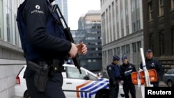 Belgian police officers secure an access to the federal police headquarters in Brussels, March 19, 2016, after Salah Abdeslam, the most-wanted fugitive from November's Paris attacks, was arrested after a shootout with police in Brussels on Friday. 