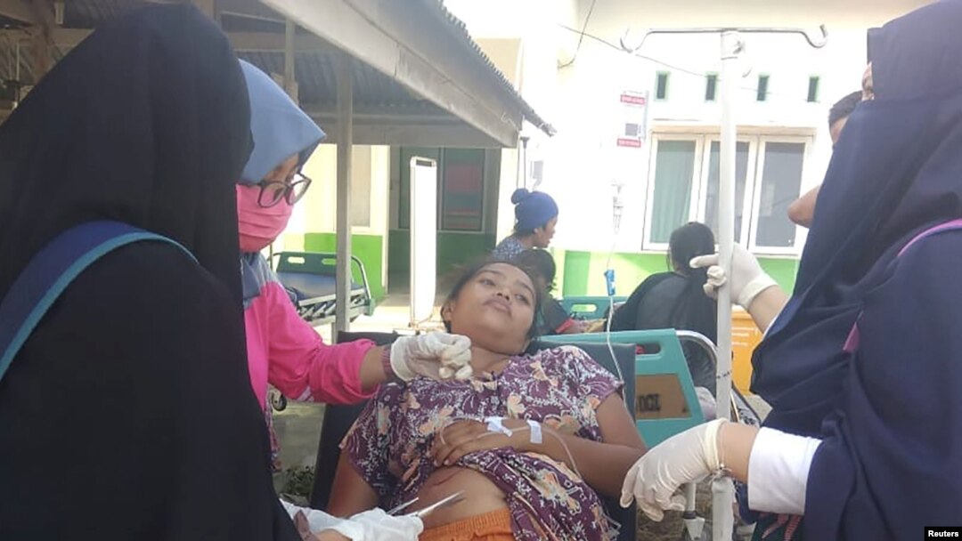Seorang paramedis memberikan pengobatan kepada korban gempa bumi di luar rumah sakit di Donggala, Sulawesi Tengah, 28 September 2018. (Antara Foto / HO / BNPB-Sutopo Purwo N via REUTERS)