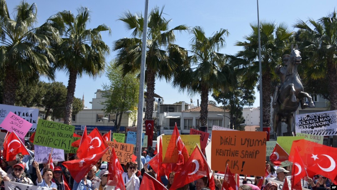 Warga melambaikan bendera nasional dalam protes melawan rencana untuk membangun kamp pengungsi di bawah perjanjian Uni Eropa-Turki di Dikili, Izmir, Turki (2/, April 2, 2016. Under the new deal refugees and migrants who arrived on Greek islands after March 2