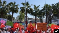 Warga melambaikan bendera nasional dalam protes melawan rencana untuk membangun kamp pengungsi di bawah perjanjian Uni Eropa-Turki di Dikili, Izmir, Turki (2/, April 2, 2016. Under the new deal refugees and migrants who arrived on Greek islands after March 2