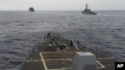 FILE - U.S. Navy ships are seen from the bridge of the guided-missile destroyer USS Spruance, in the South China Sea, Oct. 17, 2016, in a photo provided by the U.S. Navy.