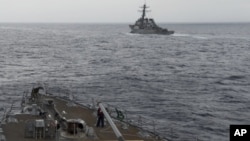 FILE - A U.S. Navy ship is seen from the bridge of the guided-missile destroyer USS Spruance, in the South China Sea, Oct. 17, 2016, in a photo provided by the U.S. Navy.