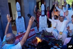 Members of India's Bharatiya Janata Party (BJP) perform Hindu rituals for the success of Indian spacecraft Chandrayaan-3, the word for "moon craft" in Sanskrit, inside a temple in Mumbai, India on July 14, 2023. (AP Photo/Rajanish Kakade)