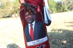 A woman waits for Mozambique President Filipe Nyusi and Renamo leader Ossufo Momade to arrive for a peace accord signing ceremony at Gorongosa National Park, about 170 kilometers from Beira, Mozambique, Aug, 1, 2019.