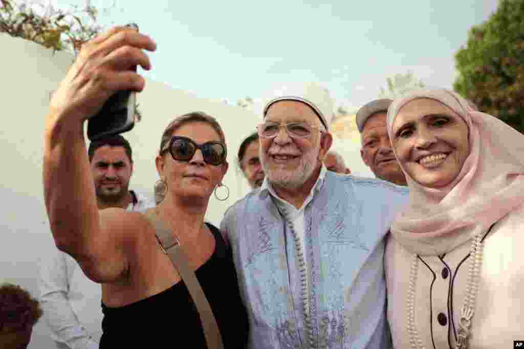 در حاشیه انتخابات ریاست جمهوری تونس، یک زن بی&zwnj;حجاب با راشد الغنوشی از رهبران اسلامگرای کشور سلفی می&zwnj;گیرد.&nbsp;