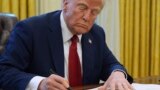 (FILE) President Donald Trump signs a document in the Oval Office at the White House, Jan. 30, 2025, in Washington. 