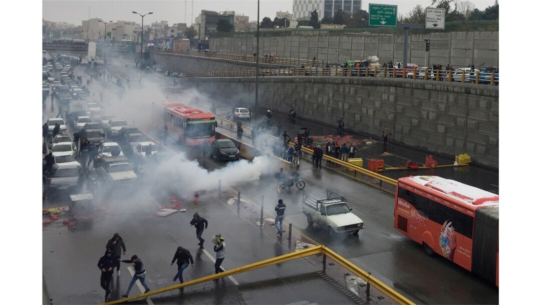 Riot police try to disperse protesters as they rally on a highway against increased fuel prices, in Tehran, Iran, Nov. 16, 2019.