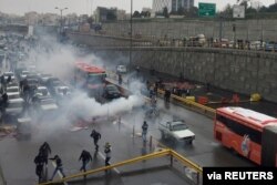 Riot police try to disperse protesters as they rally on a highway against increased fuel prices, in Tehran, Iran, Nov. 16, 2019.