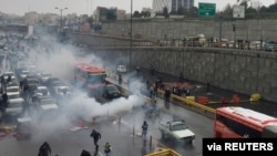 Riot police try to disperse protesters as they rally on a highway against increased fuel prices, in Tehran, Iran, Nov. 16, 2019.