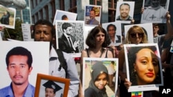 Beza Alemu, left, from Ethiopia, along with other demonstrators, holds pictures of his brother Mulusew Alemu, who died in the Boeing 737 Max 8 crash in Ethiopia, March 10, 2019. A vigil was held outside the Department of Transportation, Sept. 10, 2019.