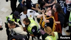Policija privodi demonstrante tokom protesta u zgradi američkog Kongresa. (REUTERS/Jonathan Ernst)