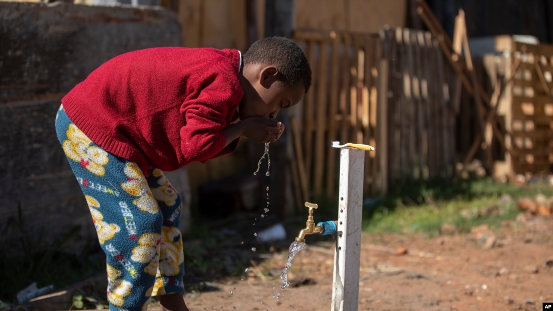 A boy brushes his teeth from a communal faucet in the Jardim Julieta squatter camp in Sao Paulo, Brazil, July 23, 2020.