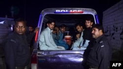 2023年11月11日，在卡拉奇郊区，警察人员深夜进行突击搜查行动，以查明涉嫌非法移民者的身份。被拘留的阿富汗难民被聚集在一辆面包车中。 (法新社图片)