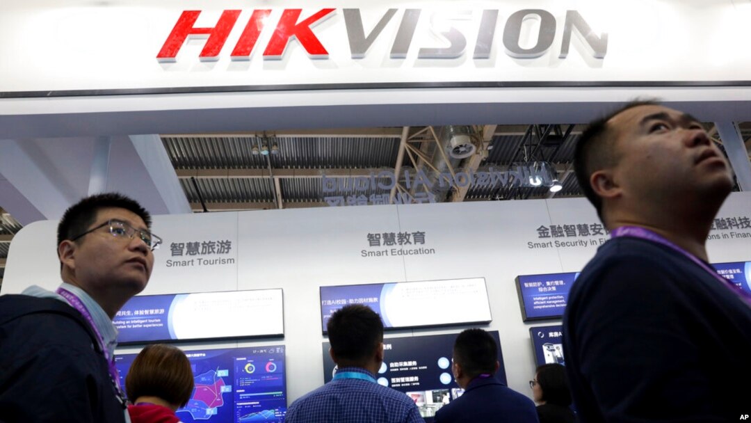 Para pengunjung melintas di depan stan produsen peralatan pengintaian China, Hikvision, di sebuah pameran di Beijing, China, 23 Oktober 2018. (Foto: AP/Ng Han Guan). 