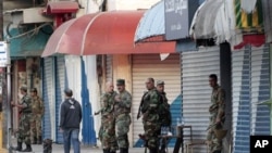 Syrian army soldiers stand guard at Sheikh Daher Square after the violence between security forces and armed groups in Latakia, northwest of Damascus, March 27, 2011