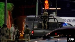 Mexican Army soldiers and a forensic expert stand guard outside the Los Cantaritos bar where an armed group broke in on the eve, killing ten people and leaving at least seven more injured, in the city of Queretaro, state of Queretaro, Nov. 10, 2024.