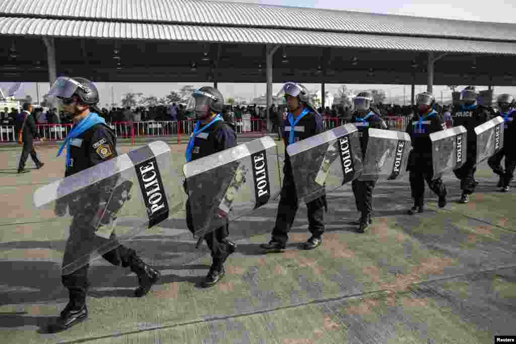 Riot policemen walk around during a registration of election candidates at a bus terminal centre near the Government complex in Bangkok.