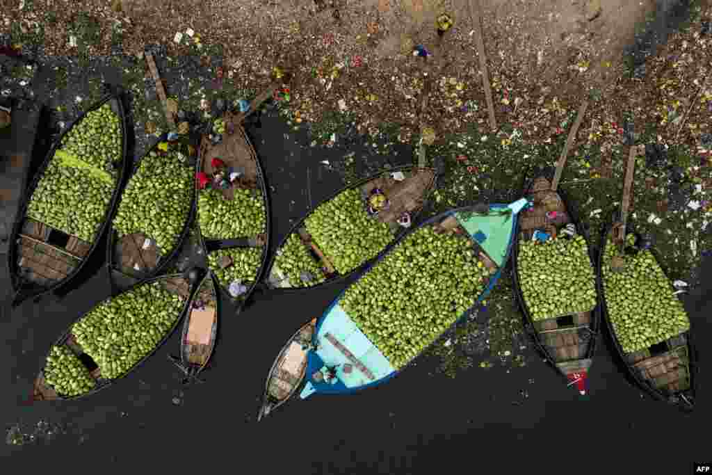 This aerial picture shows workers unloading watermelons from boats in Burigonga river during a government-imposed lockdown as a preventative measure against the spread of the COVID-19 coronavirus in Dhaka, Bangladesh.