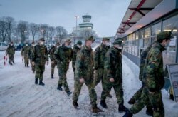 Soldiers of the German armed forces Bundeswehr wear face masks as they enter the new vaccination center on the day of its opening at the former Berlin Tegel Airport, in Berlin, Feb. 10, 2021.