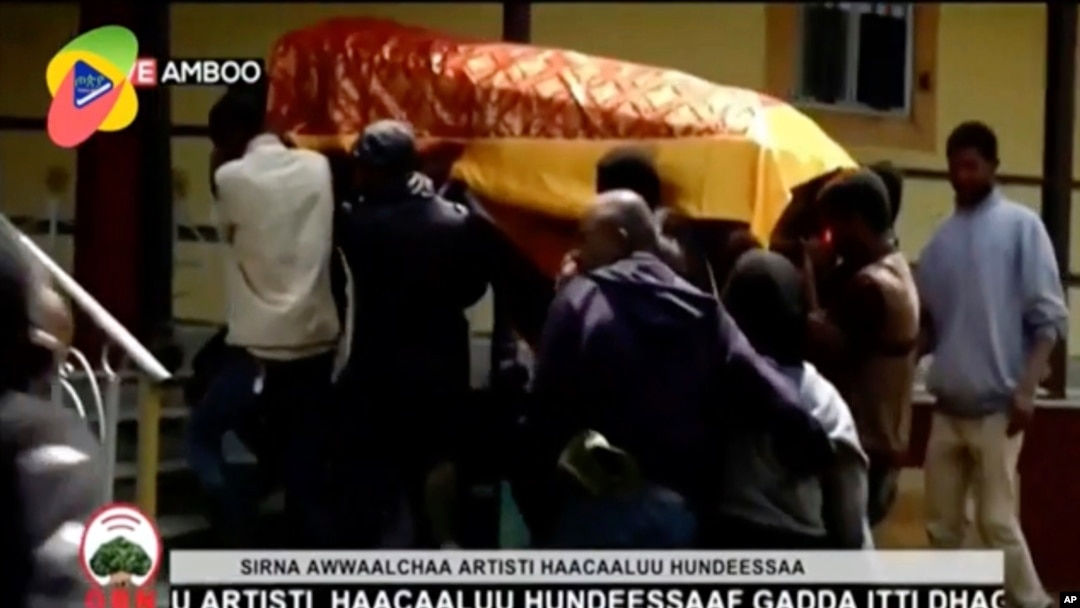 Na ovoj fotografiji napravljenoj od video snimka televizije OBN, vidi se sanduk sa telom popularnog pevača Hančulu Hundese, koga nose ljudi tokom sahrane u Ambu, Etiopija, 2. jula 2020.